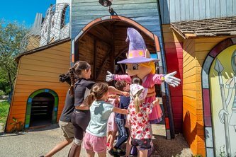 Enfants étreignant la mascotte du Camping Carpe Diem parc aquatique à Vaison-la-Romaine.